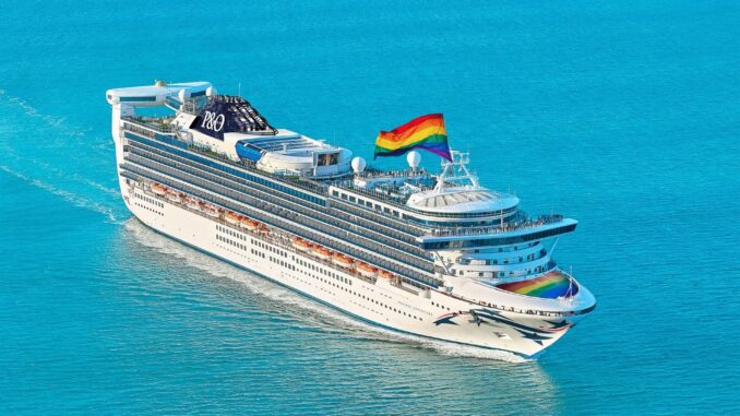 A white cruise ship flying a rainbow flag.