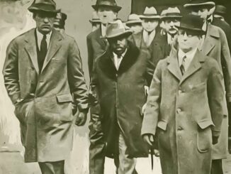 A black and white image of men in hats and trench coats walking together.