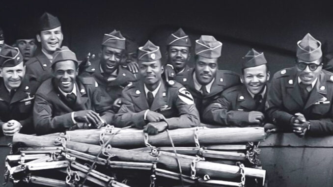 A group of American WWII soldiers standing at the railing of a ship.