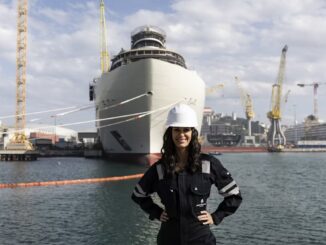 A picture of a smiling woman in a shipyard.