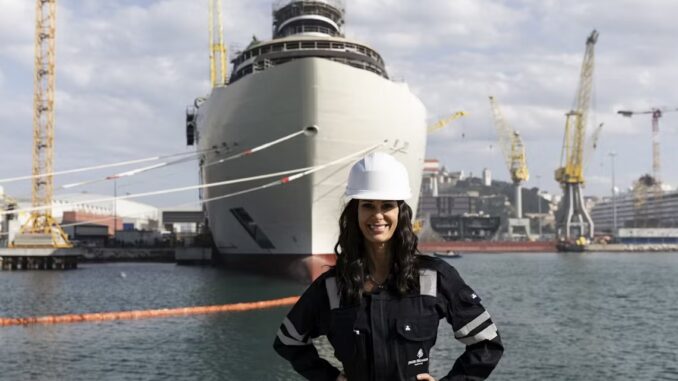 A picture of a smiling woman in a shipyard.