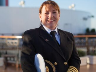 A picture of a smiling woman wearing a ship's captain uniform.