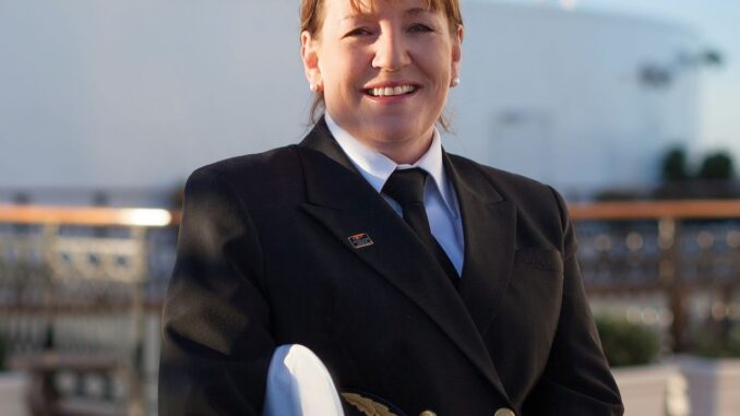 A picture of a smiling woman wearing a ship's captain uniform.