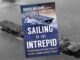 A photo of a book covers that reads "The Sailing of the Intrepid: The Incredible Wartime Voyage of the Navy's Iconic Aircraft Carrier." There is a picture of an aircraft carrier on the front.