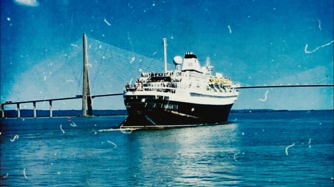 A cruise ship with a black hull and single funnel sails towards a bridge.