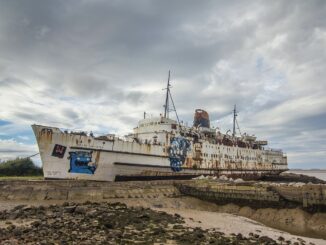 A rusted old ship covered in graffiti.
