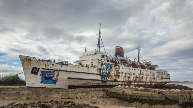A rusted old ship covered in graffiti.