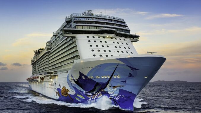 A big cruise ship with white paint and artwork featuring marine life on its hull.