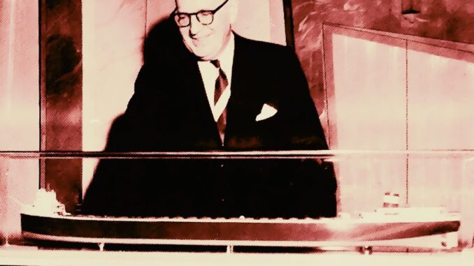 A man in a suit and tie looks at a model of a freighter.